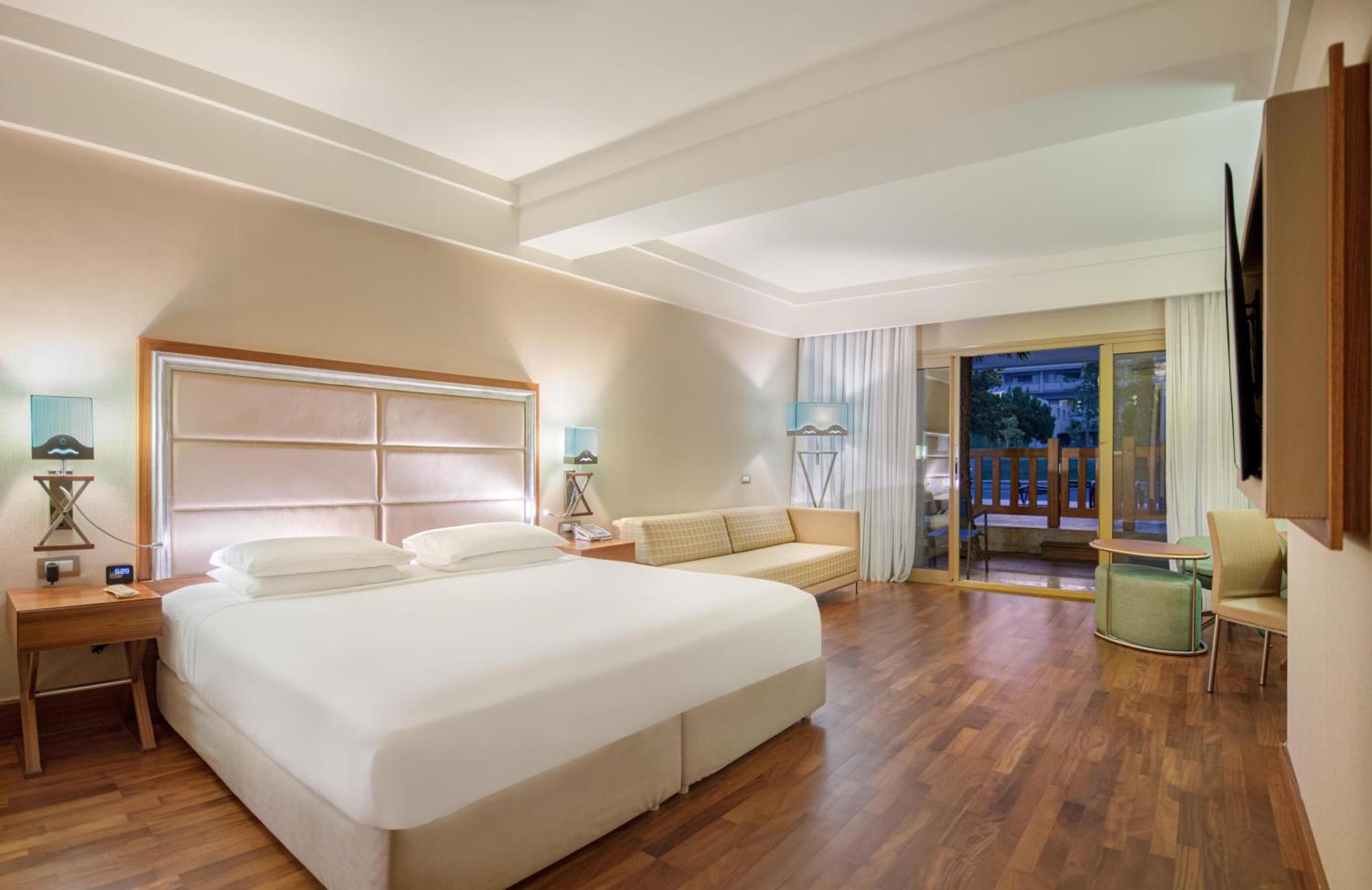 Deluxe Zimmer mit Kingsize-Bett und Poolblick.